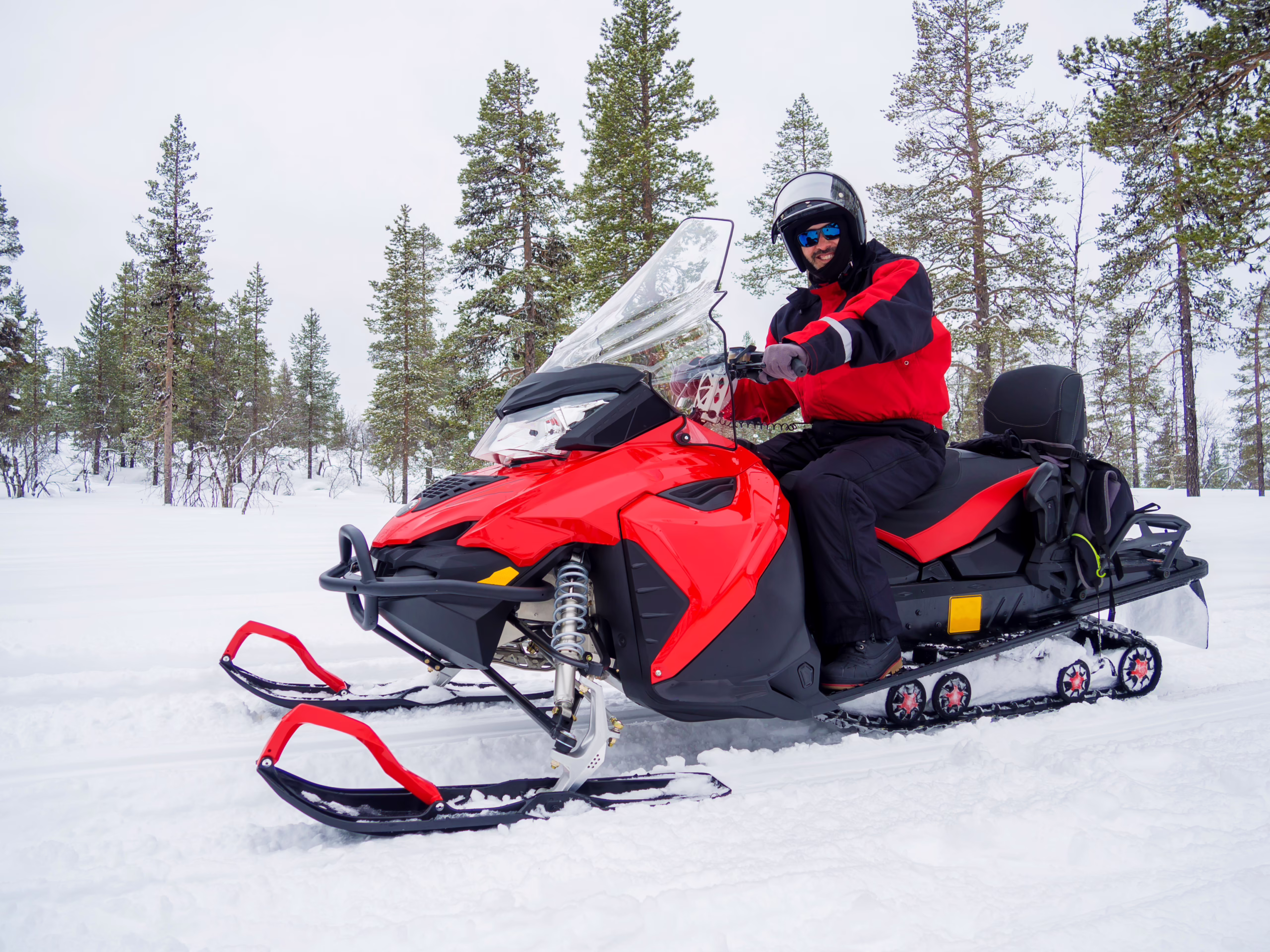 A Man On Snowmobile In Winter Mountain